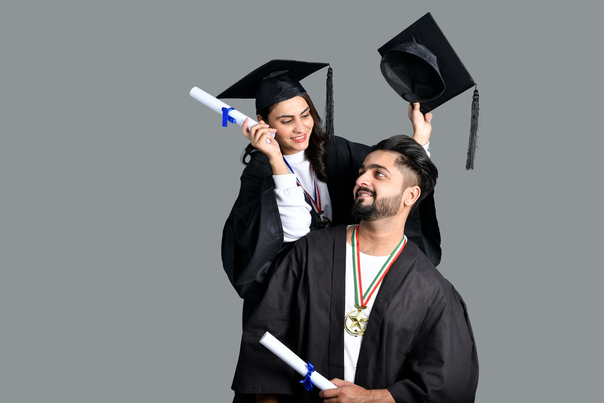 Concept Home tutors Pakistan a man and woman wearing graduation gowns and caps